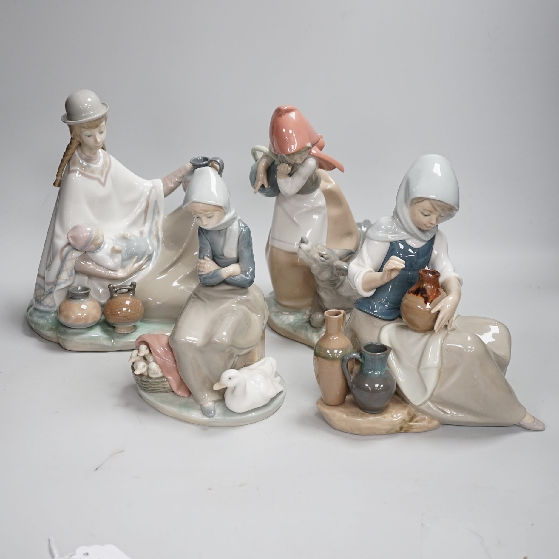 Four Lladro models, a girl potter, girl with ducks, mother and child with pottery and girl with a dog, highest 23.3cm